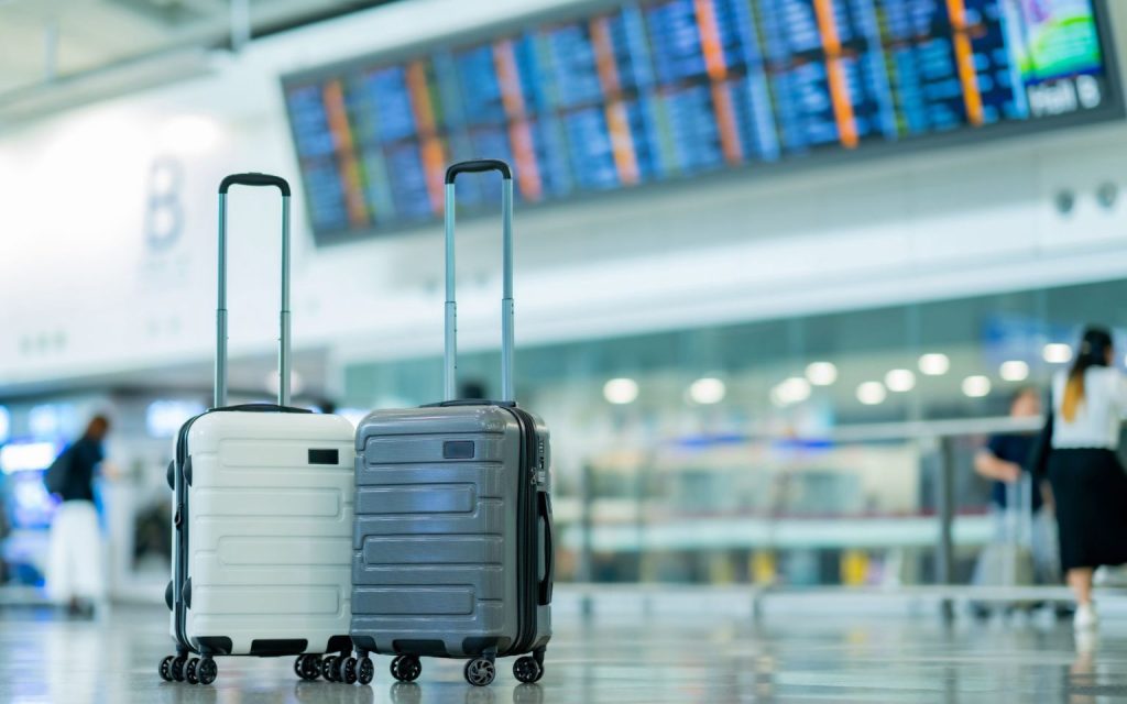 два чемодана в аэропорту у табло рейсов